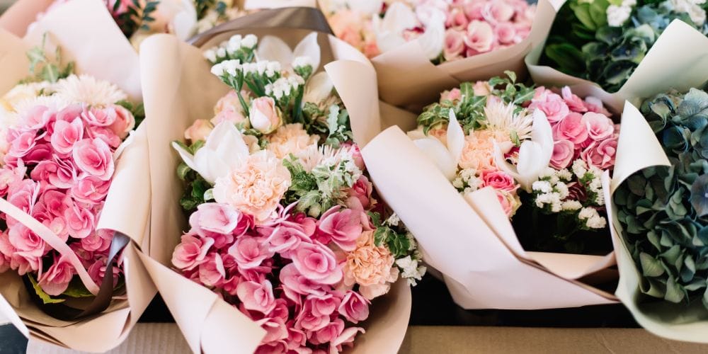 Many bouquets of flowers on a table.